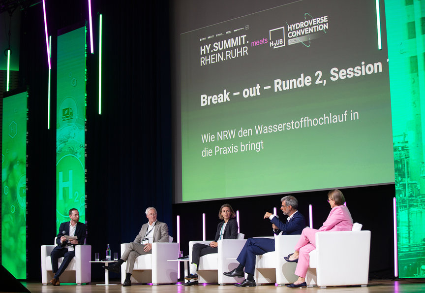 Podiumsdiskussion mit grüner Beleuchtung - Hy.Summit.Rhein.Ruhr 2026 - Eventagentur REVIERKÖNIG