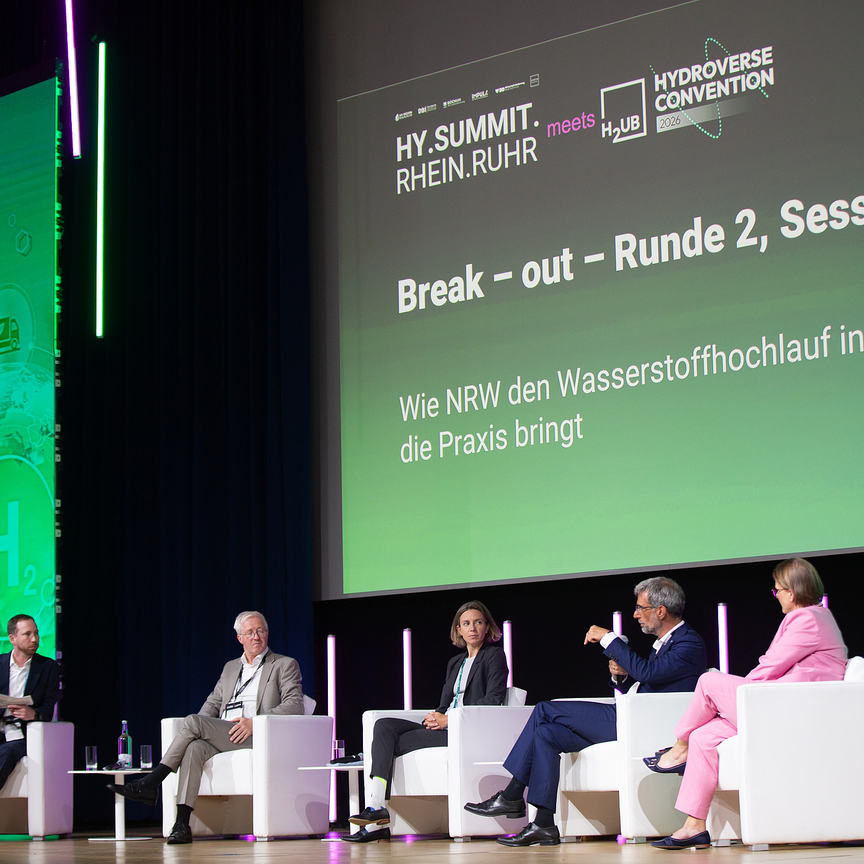 Podiumsdiskussion mit grüner Beleuchtung - Hy.Summit.Rhein.Ruhr 2026 - Eventagentur REVIERKÖNIG