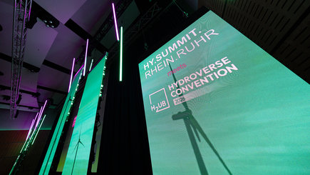Reviekönig HY Summit Grüne Stehle mir Wasserstoffmotiven - Hy.Summit.Rhein.Ruhr 2026 - Eventagentur REVIERKÖNIG